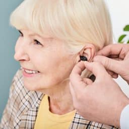Senior woman getting fitted for a hearing aid.