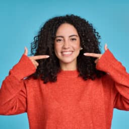 Woman points to healthy teeth