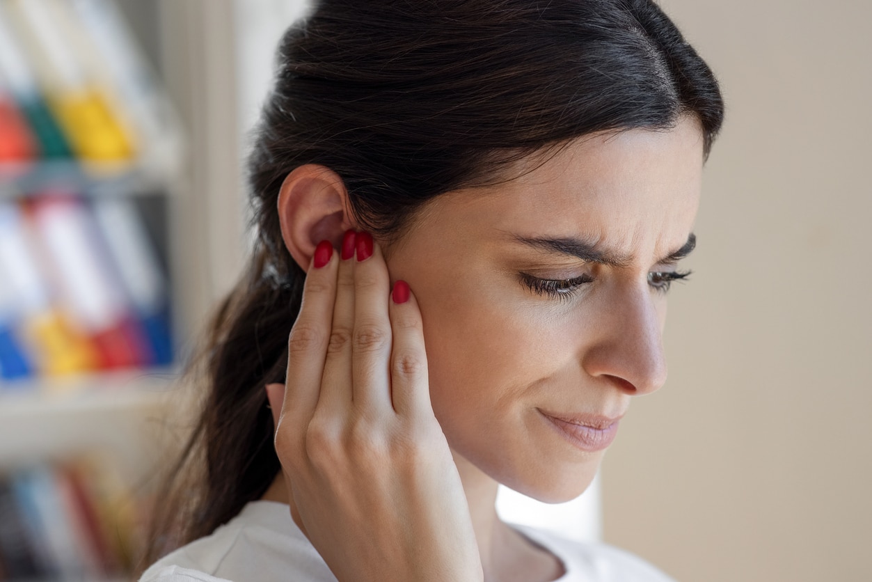 Woman holds ear