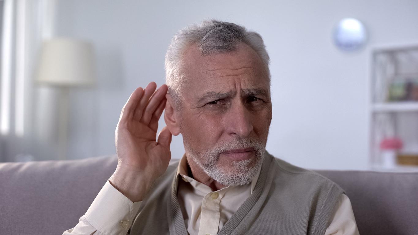 Man with hidden hearing loss struggling to hear a conversation.