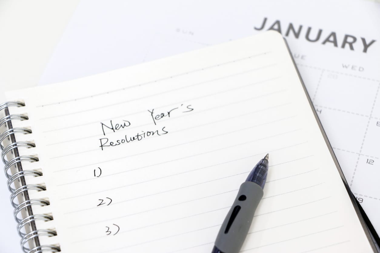 Close-up of a handwritten notebook page titled "New Year's Resolutions"; planning for new year.